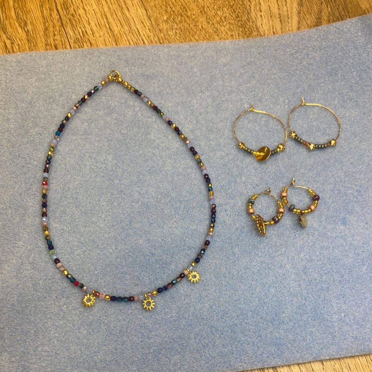 Collier perles noirs et boucles créoles dorées réalisés à l'atelier bijoux Nivelles — L'Atelier en Ville