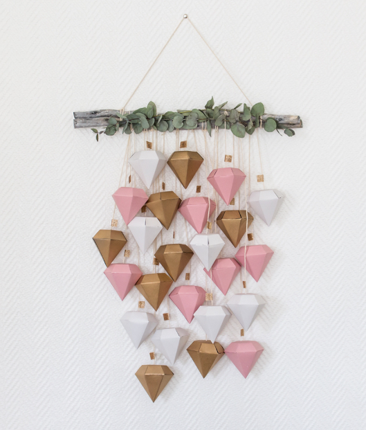 Calendrier de l'avent plein de petites boites en forme de diamants roses blancs et dorés avec une branche d'eucalyptus pour faire une belle déco murale_l'atelier en ville_nivelles