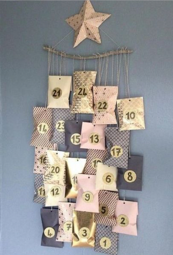 calendrier de l'avent avec des petites enveloppes décorées suspendues à un bois décoré