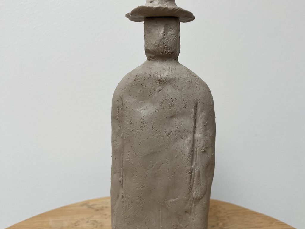 Sculpture en argile d'une silhouette avec un chapeau réalisée à L'Atelier en Ville à Nivelles