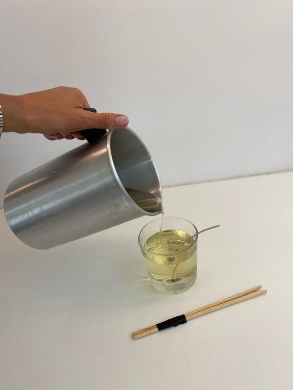 Coulage de cire végétale dans un contenant en verre lors d’un atelier refill bougies à Nivelles