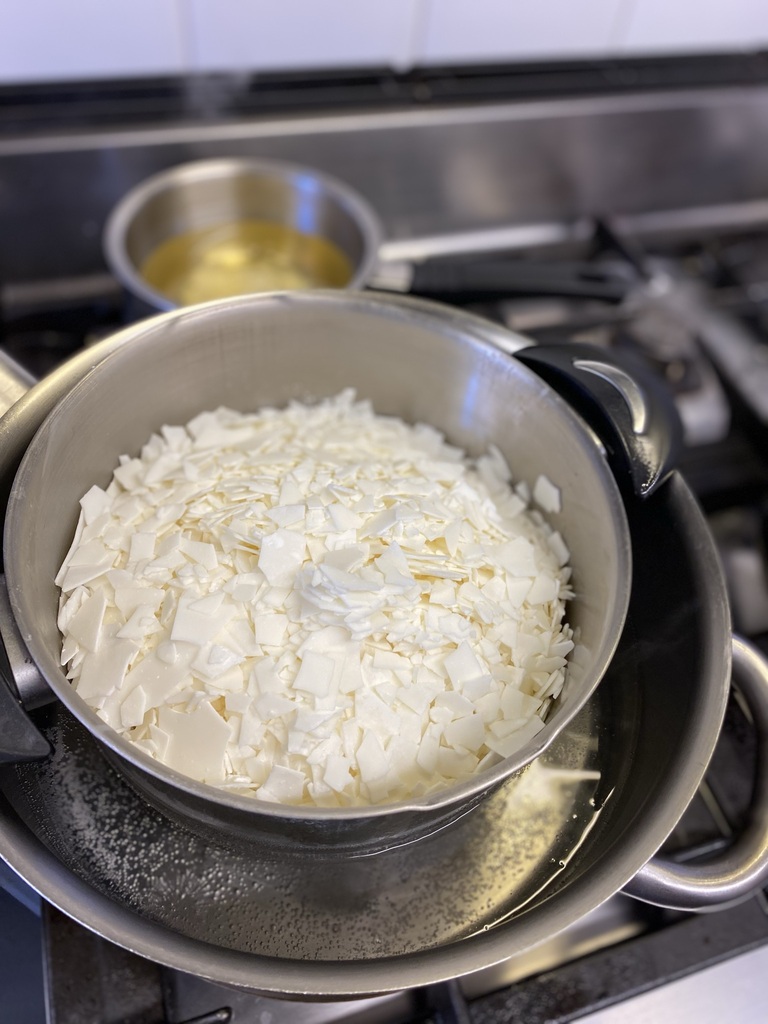 Cire végétale en paillettes fondant au bain-marie lors d’un atelier refill bougies à Nivelles